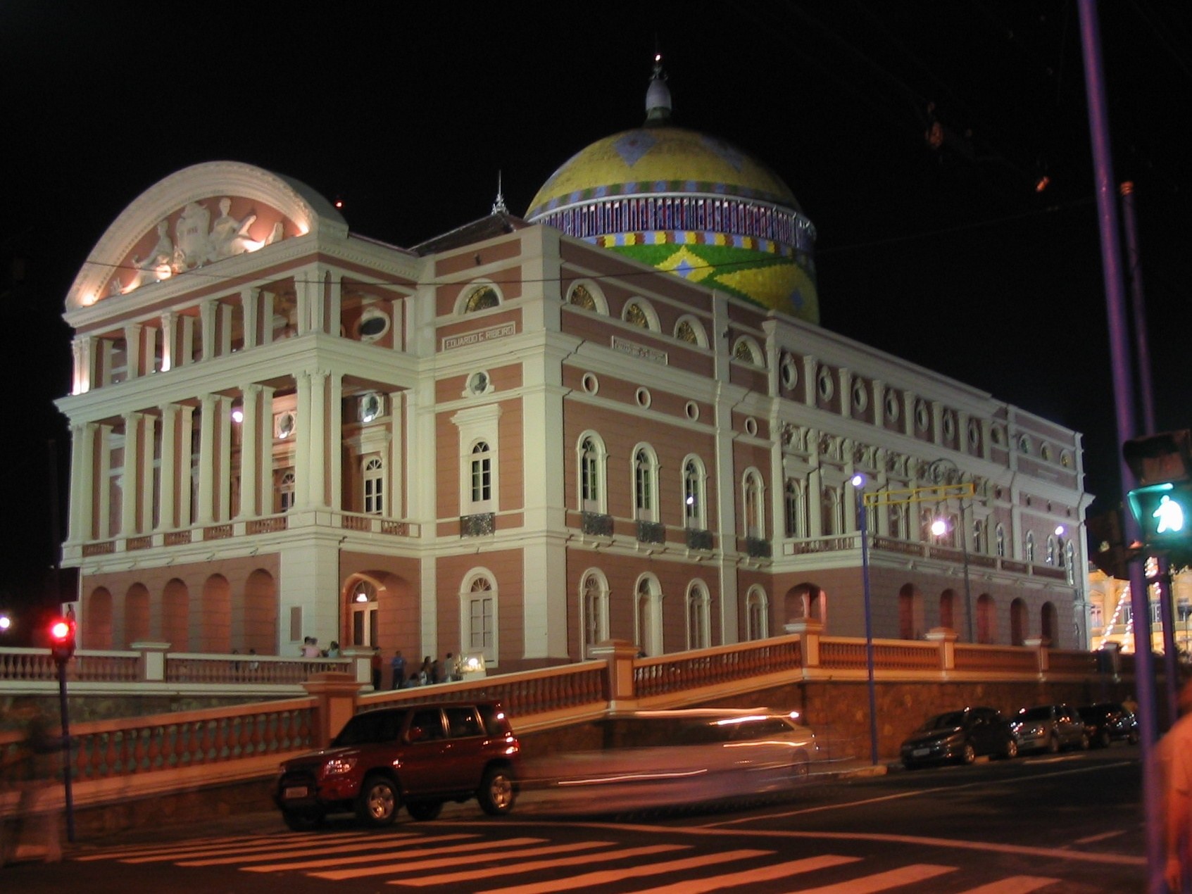 Theatro Amazonas à noite em Manaus, cúpula com o desenho da bandeira e carros na avenida.